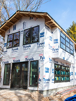 Two-story home addition in progress with brand new windows